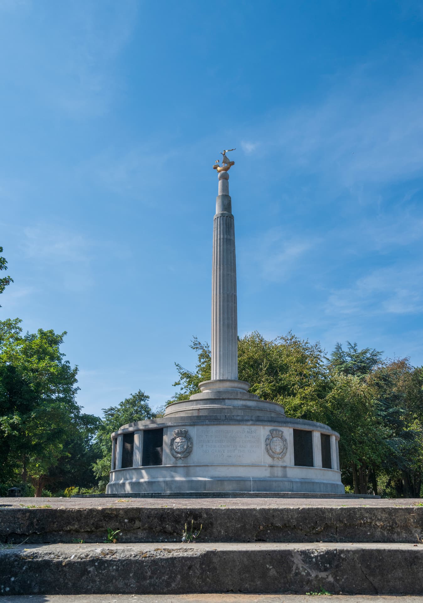 The Royal Naval Patrol Service memorial in Lowestoft, its golden ship finial against a clear blue sky