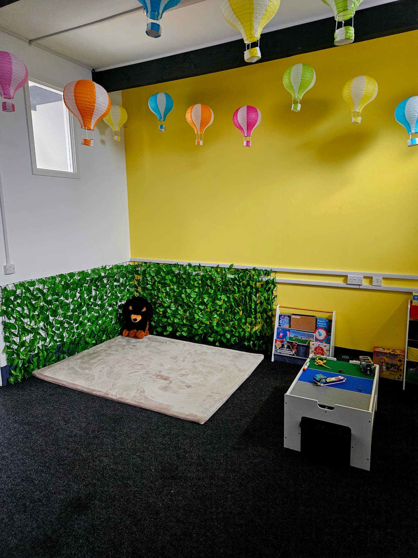 A bright, welcoming learning room with a reading corner and play activities